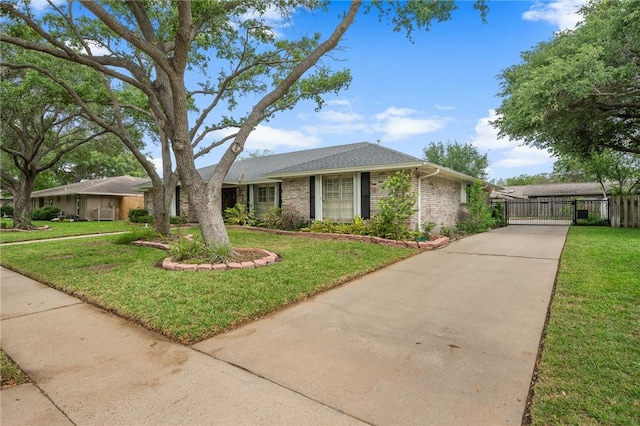 single story home featuring brick siding, fence, driveway, and a front yard