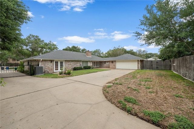 single story home featuring a chimney, a gate, a garage, central AC, and concrete driveway