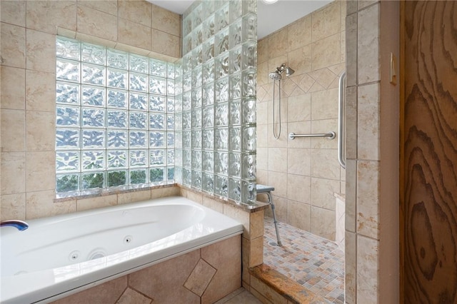 bathroom featuring walk in shower, a jetted tub, and tile walls