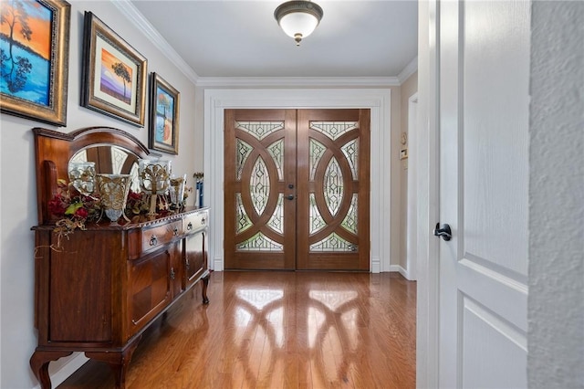 doorway with crown molding, french doors, wood finished floors, and a healthy amount of sunlight