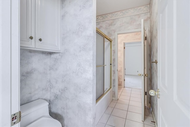 bathroom featuring toilet, shower / bath combination with glass door, and tile patterned floors