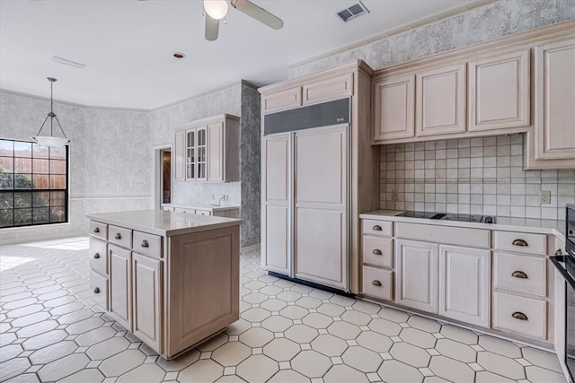 kitchen featuring black cooktop, hanging light fixtures, cream cabinetry, ceiling fan, and a center island