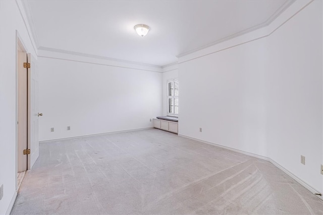 empty room featuring ornamental molding and light colored carpet