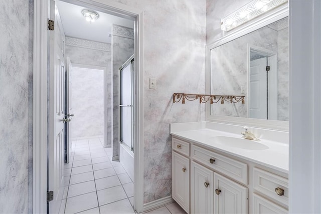 bathroom with a shower with door, vanity, and tile patterned floors