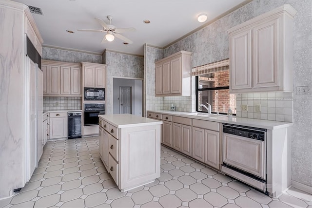 kitchen with sink, black appliances, ceiling fan, crown molding, and a center island