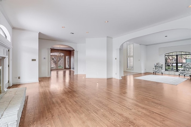 unfurnished living room with ornamental molding and light hardwood / wood-style floors