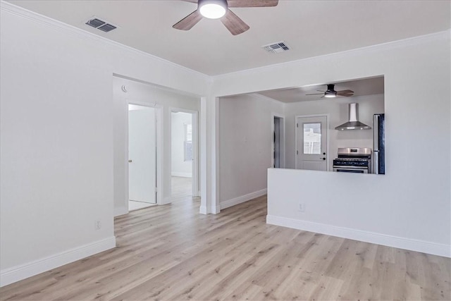 spare room featuring visible vents, light wood-style flooring, and crown molding