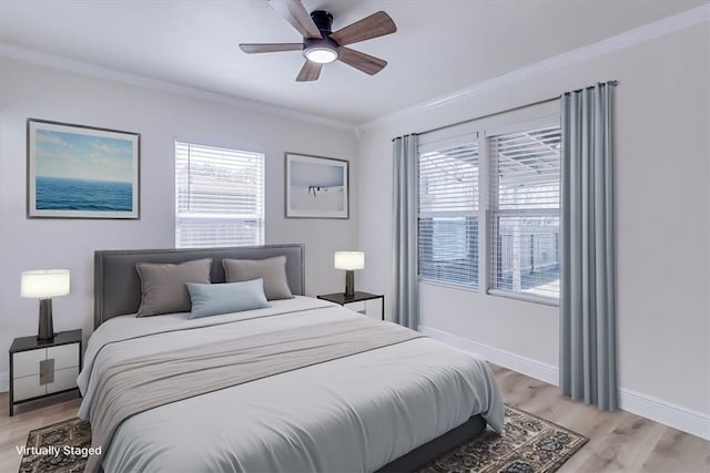 bedroom with light wood-type flooring, multiple windows, baseboards, and ornamental molding