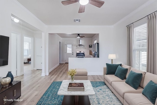 living area with wood finished floors, visible vents, baseboards, ceiling fan, and crown molding