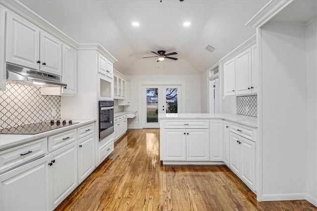 kitchen featuring light wood-type flooring, black electric stovetop, white cabinets, and wall oven