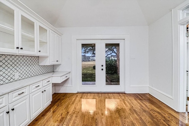 interior space featuring french doors, lofted ceiling, and light hardwood / wood-style flooring