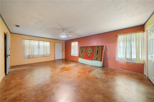 unfurnished living room with ceiling fan, a textured ceiling, and concrete floors