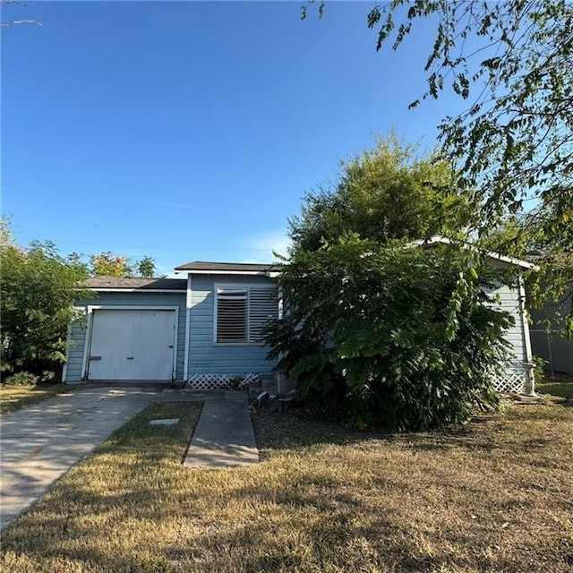 view of front facade featuring a front yard and concrete driveway