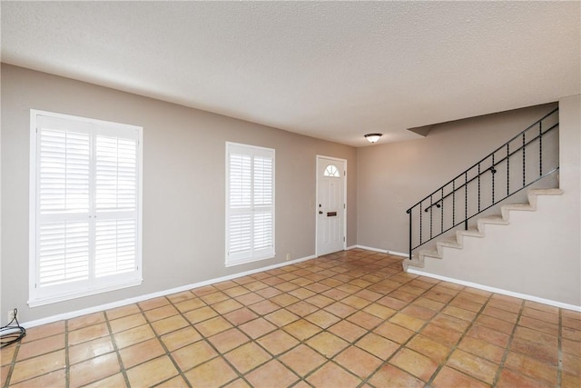 foyer featuring light tile patterned floors and a textured ceiling