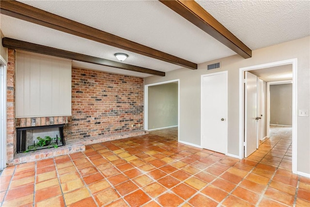41 Townhouse, Corpus Christi, TX 78412 - unfurnished living room featuring beam ceiling, a textured ceiling, brick wall, baseboards, and a brick fireplace