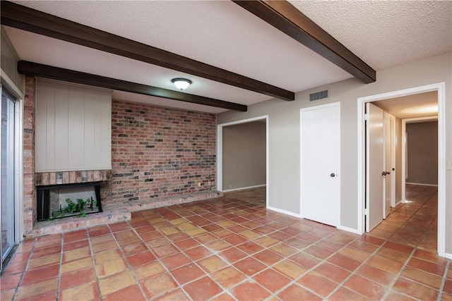 unfurnished living room featuring a fireplace, beam ceiling, and a textured ceiling