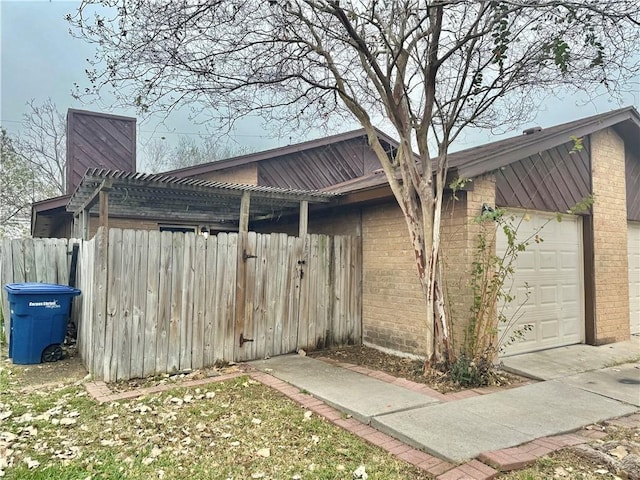 view of side of property featuring a pergola and a garage