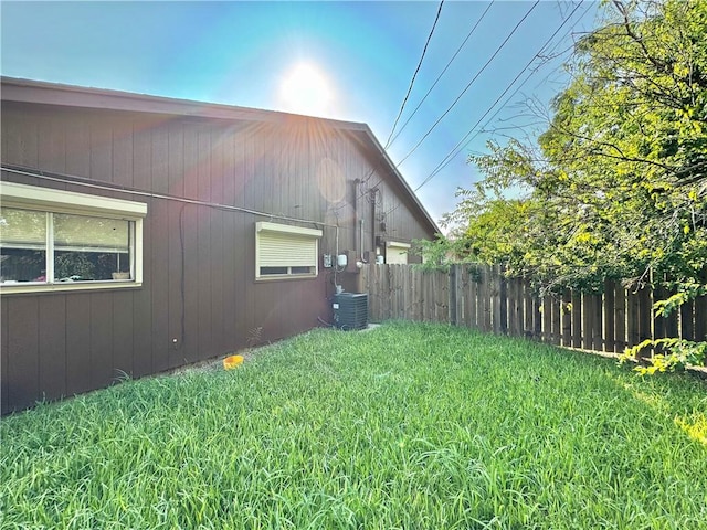 view of property exterior featuring central AC unit and a lawn