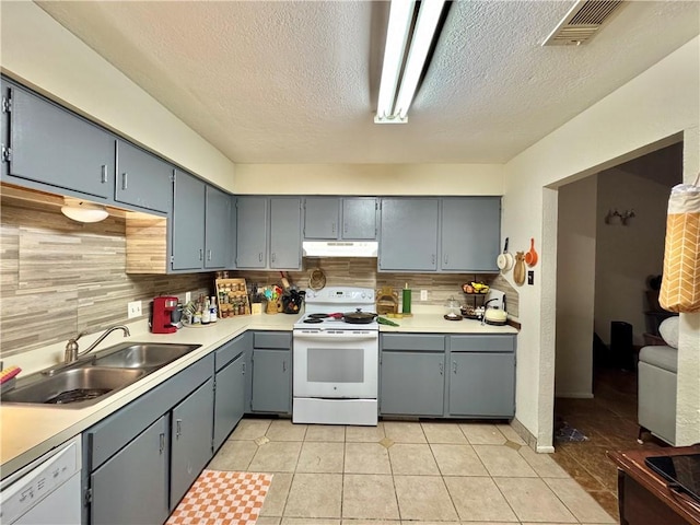 kitchen featuring sink, backsplash, a textured ceiling, white appliances, and light tile patterned flooring