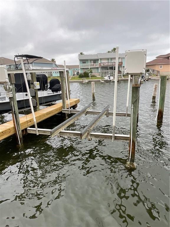 dock area with boat lift and a water view