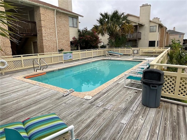 community pool with a wooden deck