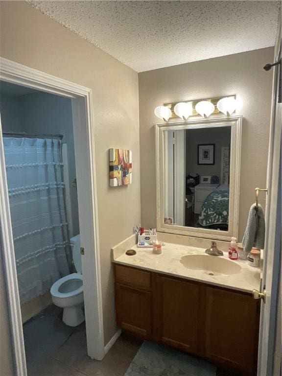 bathroom with vanity, tile patterned floors, a textured ceiling, and toilet