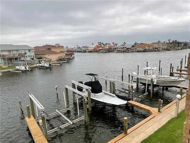 dock featuring boat lift, a water view, and a residential view