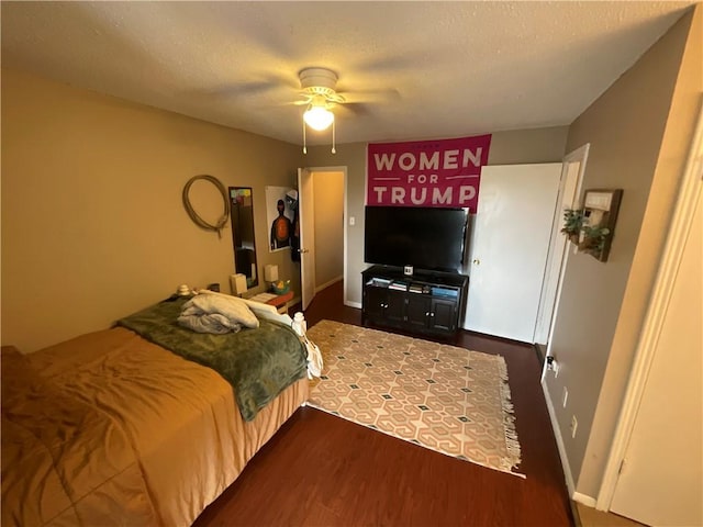 bedroom with dark wood-style floors, ceiling fan, and baseboards
