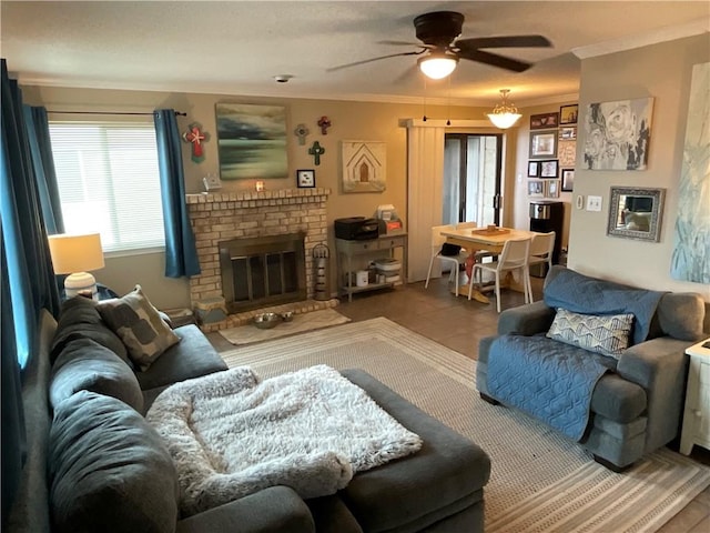 living room featuring ceiling fan, ornamental molding, and a brick fireplace