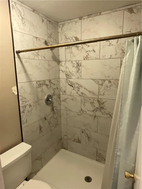 full bath featuring a stall shower and toilet