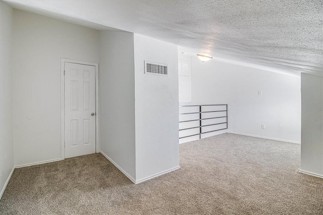 carpeted spare room with a textured ceiling