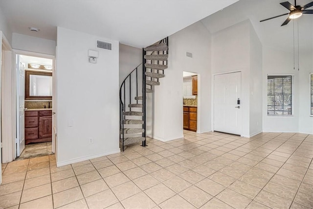 interior space featuring ceiling fan, high vaulted ceiling, and light tile patterned floors