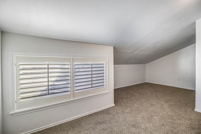 bonus room featuring vaulted ceiling and carpet