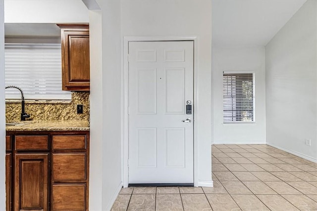 foyer entrance with light tile patterned floors and sink