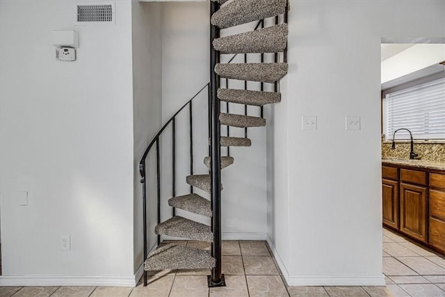 stairs featuring sink and tile patterned floors