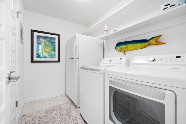 31 Bahama Dr, Rockport, TX 78382 - clothes washing area featuring light tile patterned flooring, washing machine and clothes dryer, baseboards, and laundry area