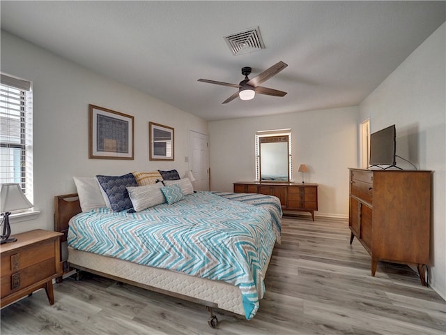 bedroom featuring light hardwood / wood-style floors, ceiling fan, and a closet