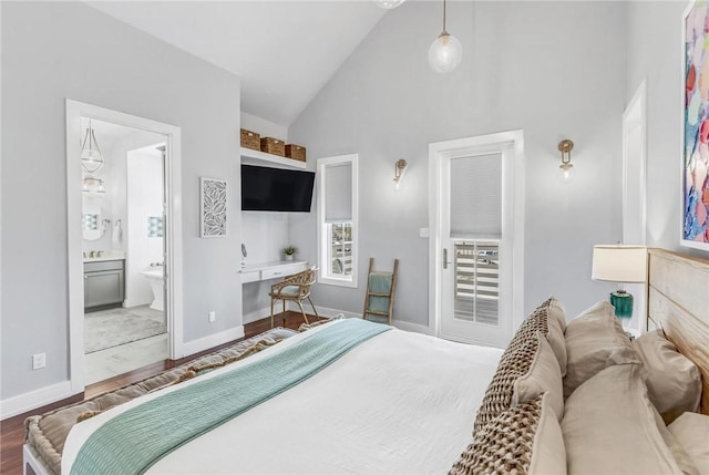 bedroom with high vaulted ceiling, wood finished floors, connected bathroom, and baseboards