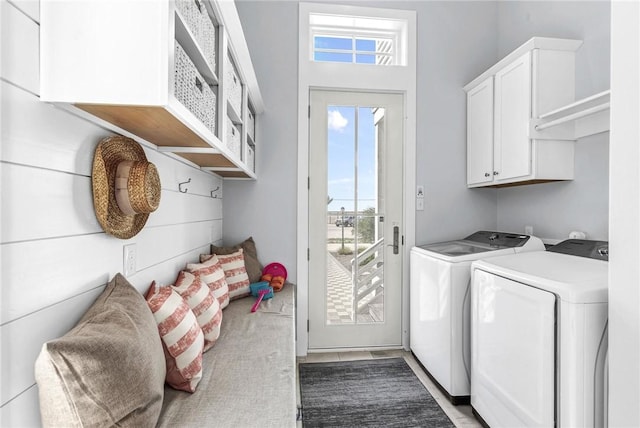 washroom featuring cabinet space and washer and clothes dryer