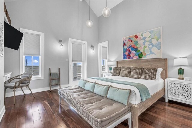 bedroom featuring high vaulted ceiling, wood-type flooring, and baseboards