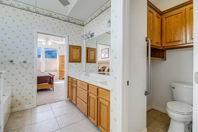 637 Pompano Dr, Aransas Pass, TX 78336 - ensuite bathroom featuring a ceiling fan, double vanity, wallpapered walls, tile patterned floors, and a bathtub