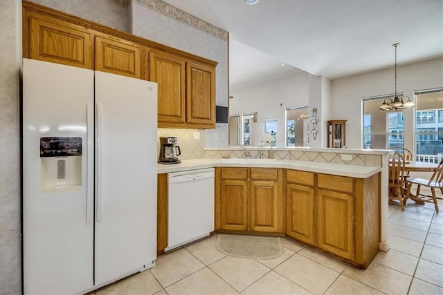 637 Pompano Dr, Aransas Pass, TX 78336 - kitchen with white appliances, brown cabinets, backsplash, light countertops, and a peninsula