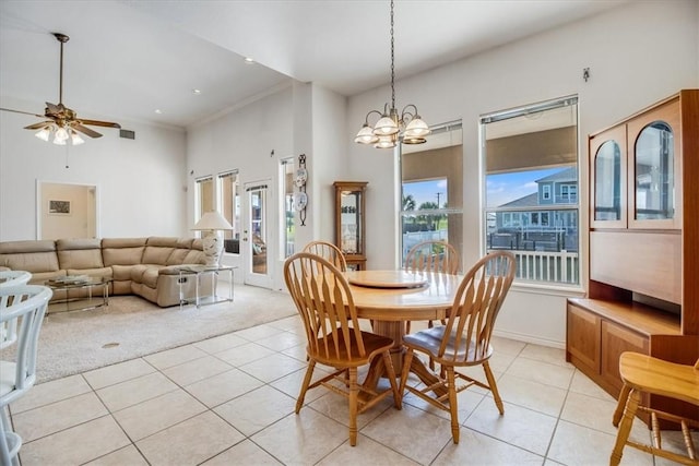 637 Pompano Dr, Aransas Pass, TX 78336 - dining area with light tile patterned floors, light colored carpet, ceiling fan, a chandelier, and a towering ceiling