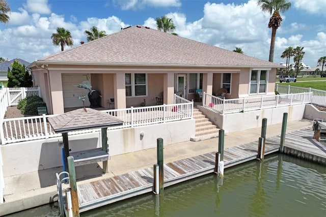637 Pompano Dr, Aransas Pass, TX 78336 - back of property featuring stucco siding, a shingled roof, and a water view