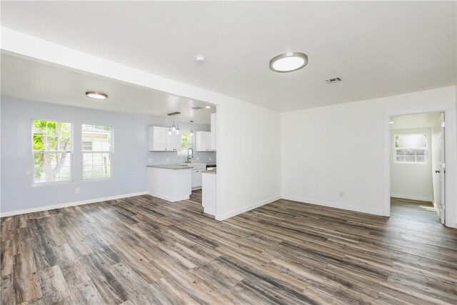 1336 Brentwood Dr, Corpus Christi, TX 78415 - unfurnished living room with dark wood-style floors, a sink, and baseboards