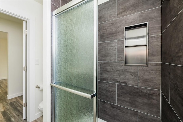 1336 Brentwood Dr, Corpus Christi, TX 78415 - bathroom with toilet, a stall shower, wood finished floors, and baseboards