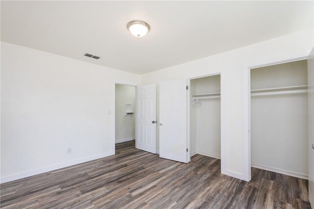 1336 Brentwood Dr, Corpus Christi, TX 78415 - unfurnished bedroom featuring wood finished floors, two closets, and baseboards
