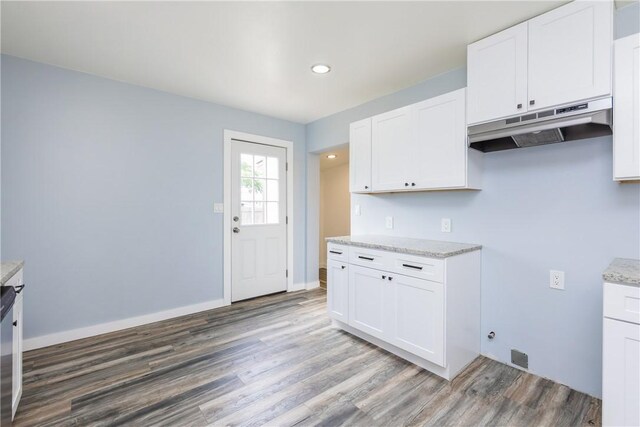1336 Brentwood Dr, Corpus Christi, TX 78415 - kitchen featuring under cabinet range hood, wood finished floors, white cabinetry, light stone countertops, and recessed lighting