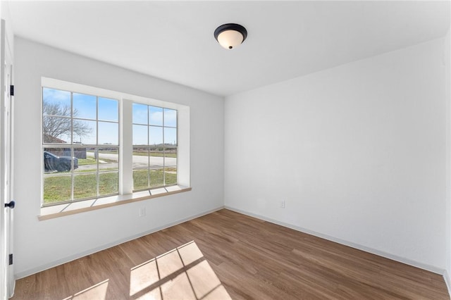 empty room featuring baseboards and wood finished floors