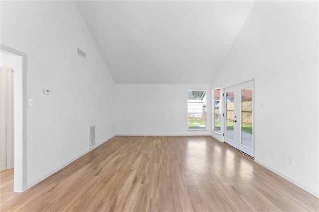 interior space featuring light wood-style floors, visible vents, french doors, and high vaulted ceiling